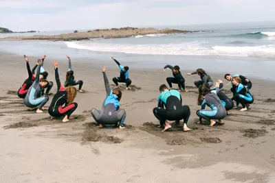 Alumnos disfrutando del surf en la playa de Frexulfe